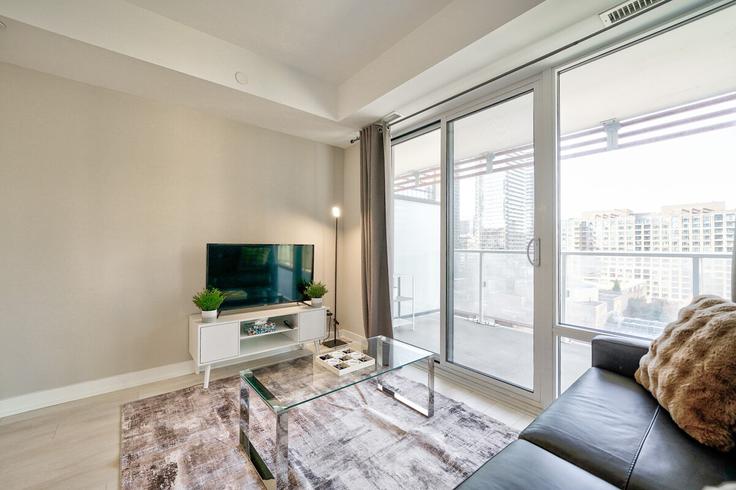 Sala de estar elegantemente projetada com móveis modernos em um apartamento no Building Maitland Terrace - 2574902-ontario-inc - 1513149 em Old Toronto, Toronto