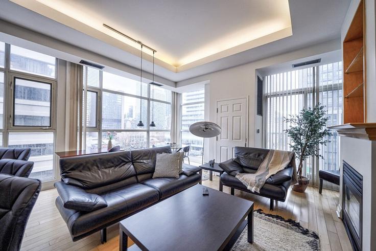 Elegante sala de estar con mobiliario moderno en un apartamento en Building Wellesley Street East - 2574902-ontario-inc - 1513104 en Old Toronto, Toronto