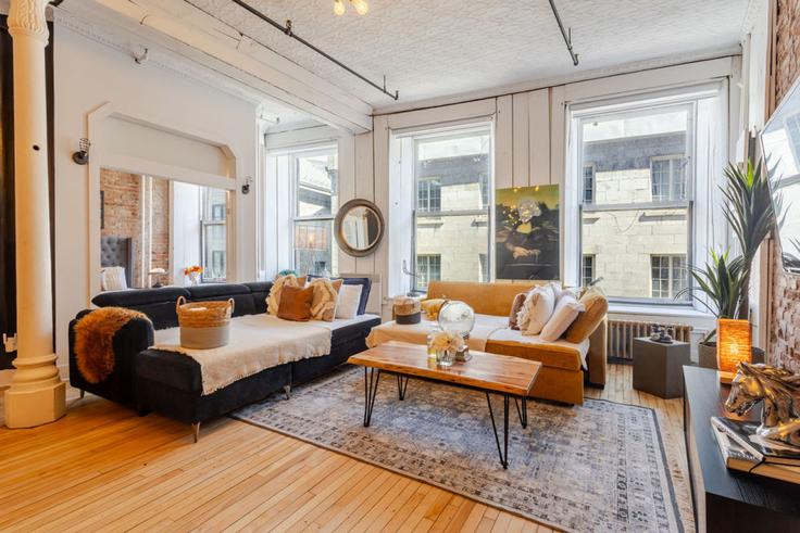 Elegante sala de estar con mobiliario moderno en un apartamento en Building Rue Saint-Paul Ouest - 9547-9267-quebec-inc - 1601970 en Ville-Marie, Montreal Elegante sala de estar con mobiliario moderno en un apartamento en Building Rue Saint-Paul Ouest - 9547-9267-quebec-inc - 1601970 en Ville-Marie, Montreal