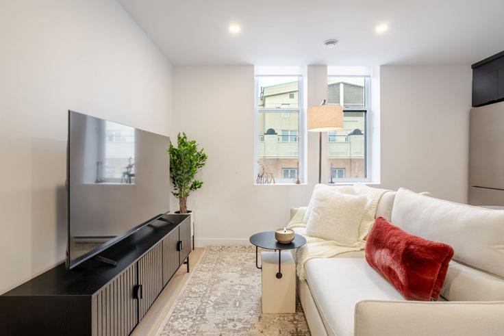 Elegante sala de estar con mobiliario moderno en un apartamento en Building Rue Sainte-Catherine Ouest - 9547-9267-quebec-inc - 1602033 en Ville-Marie, Montreal Elegante sala de estar con mobiliario moderno en un apartamento en Building Rue Sainte-Catherine Ouest - 9547-9267-quebec-inc - 1602033 en Ville-Marie, Montreal