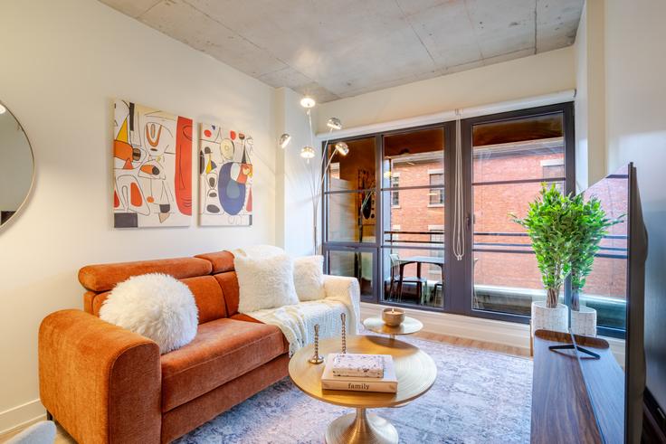 Sala de estar elegantemente projetada com móveis modernos em um apartamento no Building Rue Wellington - 9547-9267-quebec-inc - 1602102 em Ville-Marie, Montreal Sala de estar elegantemente projetada com móveis modernos em um apartamento no Building Rue Wellington - 9547-9267-quebec-inc - 1602102 em Ville-Marie, Montreal