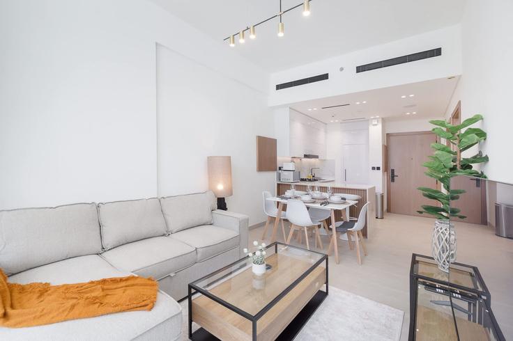 Elegante sala de estar con mobiliario moderno en un apartamento en Building Street 5 - airdxb - 1274229 - DXB en Jumeirah Village, Dubai