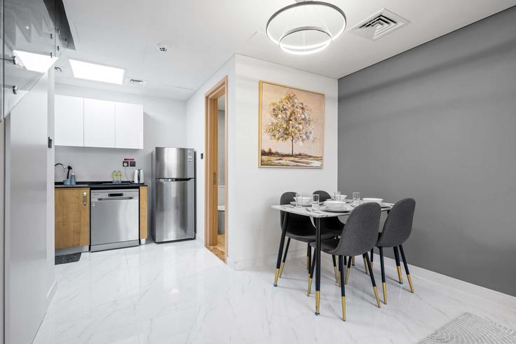 Mesa de jantar com cadeiras elegantes em um apartamento no Building Tariaq Bedon Esm - airdxb - 1344350 em Wadi Al Safa 7, Dubai