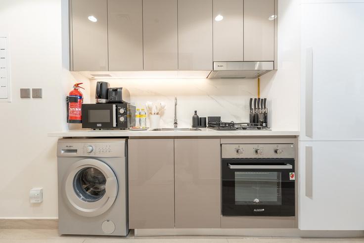 Building Azizi Riviera 45 - airdxb - 1030761 - DXB adresindeki lüks bir dairede en üst düzey ekipmanlara sahip işlevsel ve şık mutfak Nad Al Sheba, Dubai