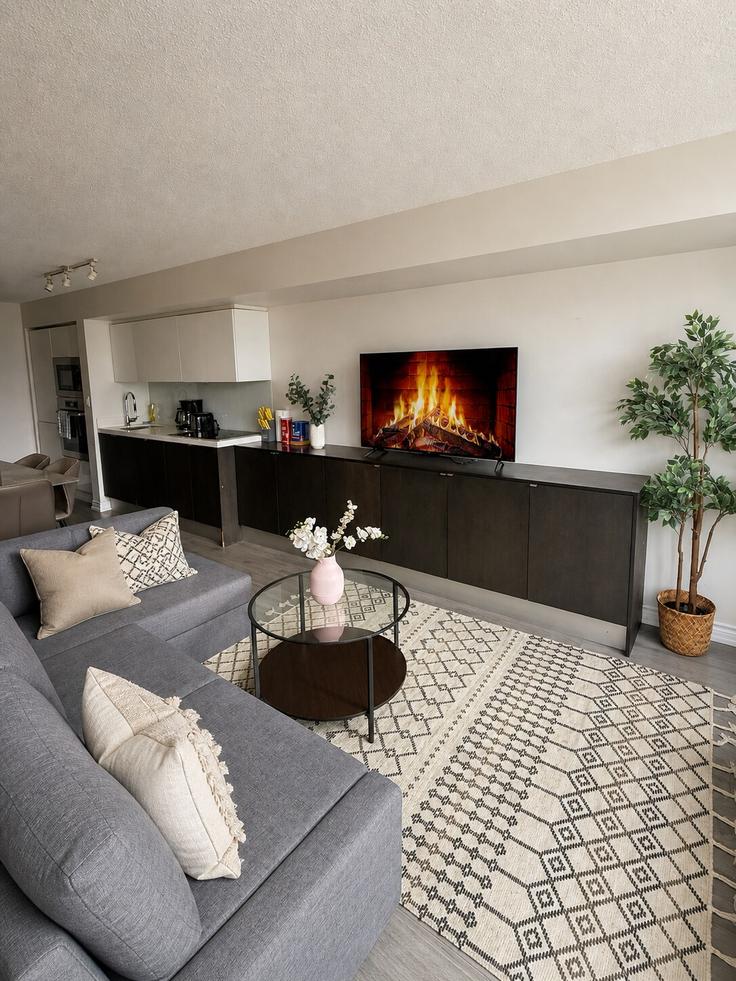 Elegante sala de estar con mobiliario moderno en un apartamento en Building Dan Leckie Way - aj-properties - 1473068 en Old Toronto, Toronto