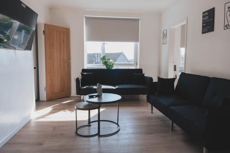 Elegante sala de estar con mobiliario moderno en un apartamento en Building Castlemilk Road - broomling-stays-ltd - 1472149 en Rutherglen, Glasgow Elegante sala de estar con mobiliario moderno en un apartamento en Building Castlemilk Road - broomling-stays-ltd - 1472149 en Rutherglen, Glasgow