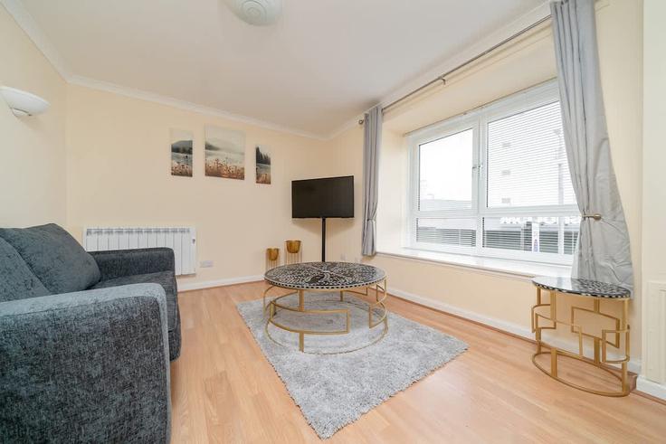 Elegante sala de estar con mobiliario moderno en un apartamento en Building Houldsworth Street - broomling-stays-ltd - 1472146 en Anderston, Glasgow Elegante sala de estar con mobiliario moderno en un apartamento en Building Houldsworth Street - broomling-stays-ltd - 1472146 en Anderston, Glasgow