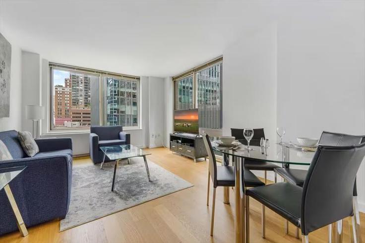 Sala de estar elegantemente projetada com móveis modernos em um apartamento no Building West 54th Street - churchillliving - 1263919 - NYC em Manhattan, New York Sala de estar elegantemente projetada com móveis modernos em um apartamento no Building West 54th Street - churchillliving - 1263919 - NYC em Manhattan, New York