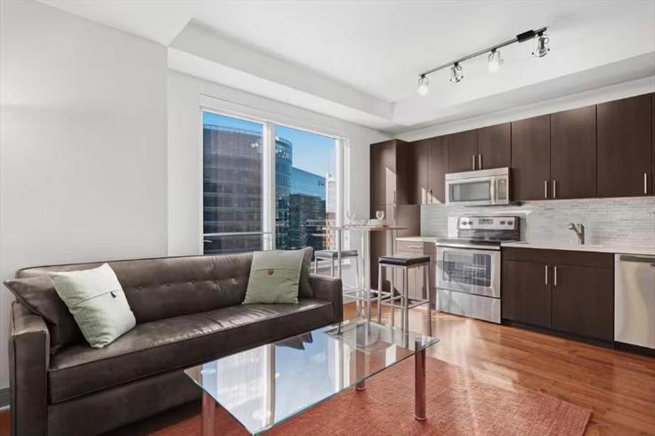 Sala de estar elegantemente projetada com móveis modernos em um apartamento no Building Bond Drive - churchillliving - 1296000 - BOS em Boston, Boston Sala de estar elegantemente projetada com móveis modernos em um apartamento no Building Bond Drive - churchillliving - 1296000 - BOS em Boston, Boston