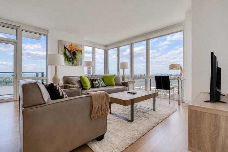 Sala de estar elegantemente projetada com móveis modernos em um apartamento no Building West 42nd Street - churchillliving - 1016413 - NYC em Manhattan, New York Sala de estar elegantemente projetada com móveis modernos em um apartamento no Building West 42nd Street - churchillliving - 1016413 - NYC em Manhattan, New York