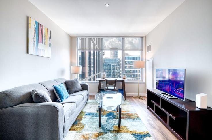 Sala de estar elegantemente projetada com móveis modernos em um apartamento no Building Fan Pier Boulevard - compassfurnishedapartments - 1050411 - BOS em Boston, Boston