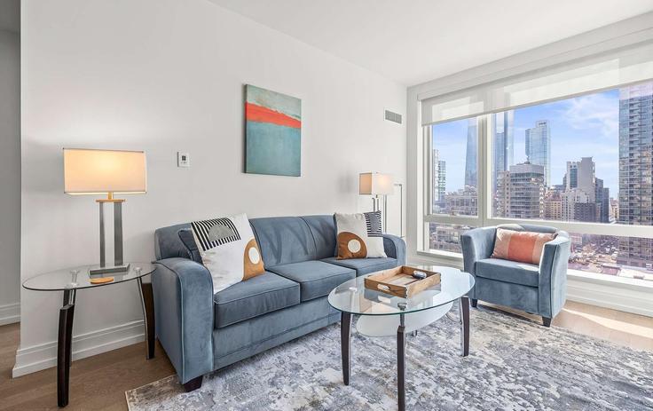 Sala de estar elegantemente projetada com móveis modernos em um apartamento no Building 10th Avenue - compassfurnishedapartments - 1475806 em Manhattan, New York Sala de estar elegantemente projetada com móveis modernos em um apartamento no Building 10th Avenue - compassfurnishedapartments - 1475806 em Manhattan, New York