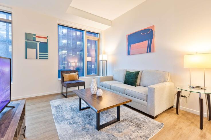 Sala de estar elegantemente projetada com móveis modernos em um apartamento no Building Seaport Boulevard - compassfurnishedapartments - 1534383 em Boston, Boston