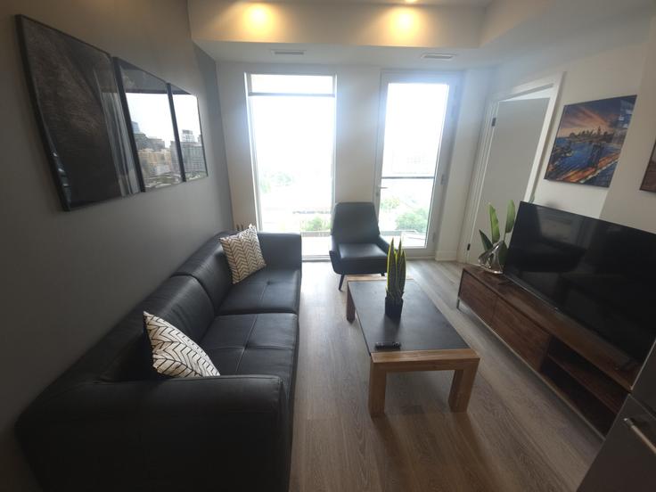 Salle de séjour élégante avec mobilier moderne dans un appartement à Building Mutual Street - corporate-stays - 1375285 à Old Toronto, Toronto