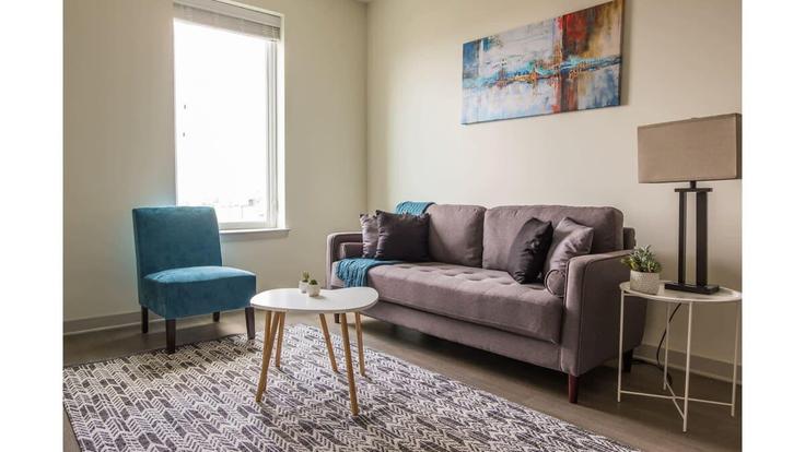Sala de estar elegantemente projetada com móveis modernos em um apartamento no Building East Main Street - cozysuites-guesty - 1014626 em Louisville, Louisville