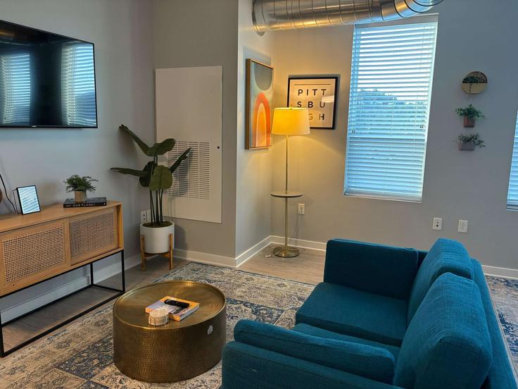 Sala de estar elegantemente projetada com móveis modernos em um apartamento no Building Foster Street - cozysuites-guesty - 1344552 em Pittsburgh, Pittsburgh Sala de estar elegantemente projetada com móveis modernos em um apartamento no Building Foster Street - cozysuites-guesty - 1344552 em Pittsburgh, Pittsburgh