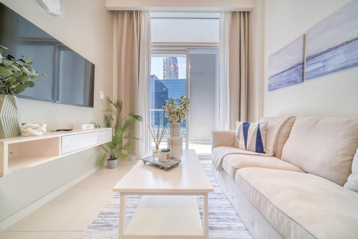 Elegante sala de estar con mobiliario moderno en un apartamento en Building Marasi Drive - dlx-holiday-homes - 1238765 - DXB en Business Bay, Dubai