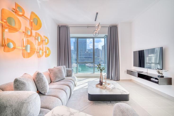 Elegante sala de estar con mobiliario moderno en un apartamento en Building Marina Promenade - dlx-holiday-homes - 1238901 - DXB en Dubai Marina, Dubai