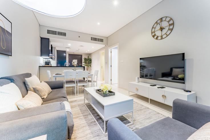Sala de estar elegantemente projetada com móveis modernos em um apartamento no Building Marasi Drive - dlx-holiday-homes - 1239280 - DXB em Business Bay, Dubai Sala de estar elegantemente projetada com móveis modernos em um apartamento no Building Marasi Drive - dlx-holiday-homes - 1239280 - DXB em Business Bay, Dubai