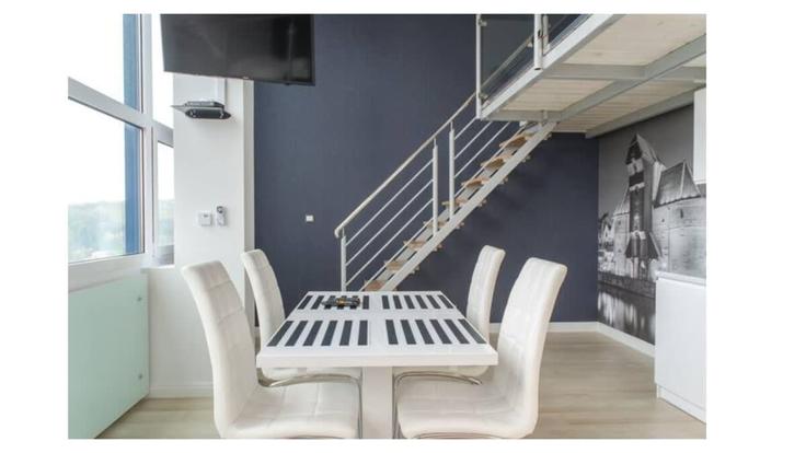 Table de salle à manger avec chaises stylisées dans un appartement à Building aleja Grunwaldzka - elite-apartments - 1320006 dans Gdańsk, Gdańsk Table de salle à manger avec chaises stylisées dans un appartement à Building aleja Grunwaldzka - elite-apartments - 1320006 dans Gdańsk, Gdańsk