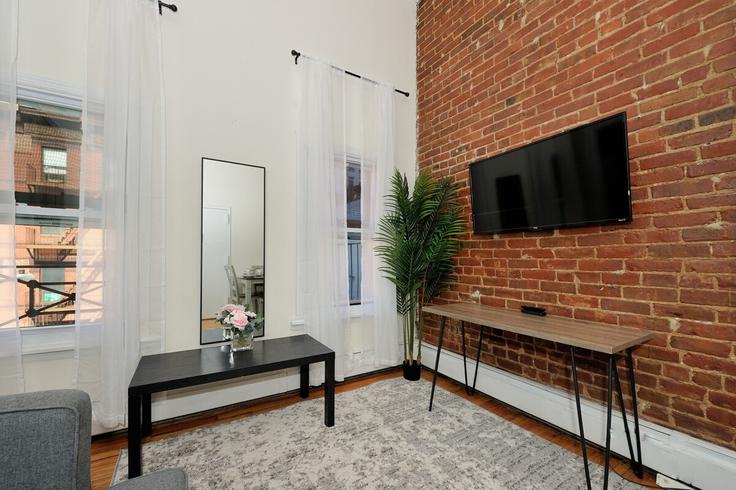 Elegante sala de estar con mobiliario moderno en un apartamento en Building 9th Avenue - furnishedhabitat - 1323896 en Manhattan, New York Elegante sala de estar con mobiliario moderno en un apartamento en Building 9th Avenue - furnishedhabitat - 1323896 en Manhattan, New York