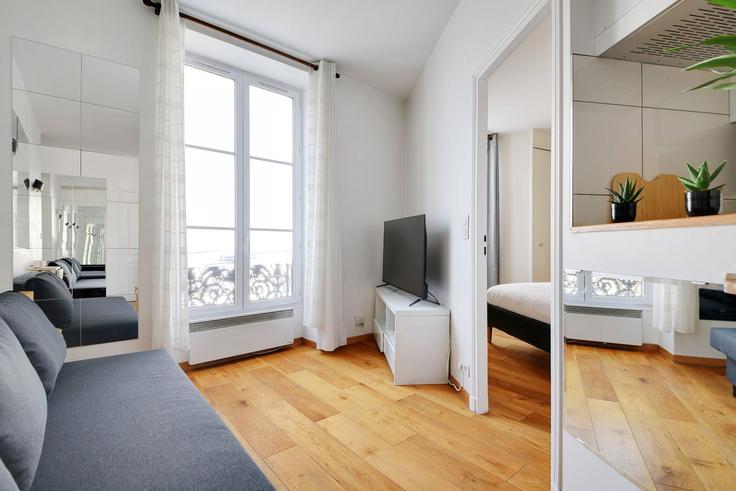 Sala de estar elegantemente projetada com móveis modernos em um apartamento no Building 6 Place Gustave Toudouze, 75009 Paris, France - guestready - 1598679 em 9th arrondissement, Paris