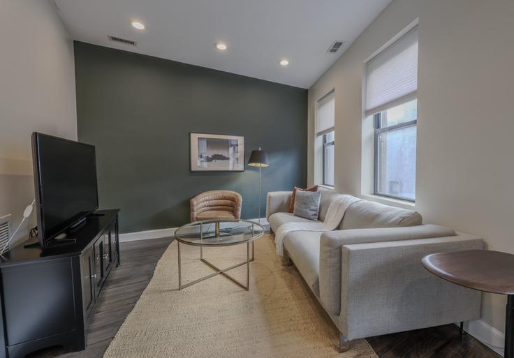 Sala de estar elegantemente projetada com móveis modernos em um apartamento no Building Commercial Wharf North - healinghomesofboston - 1345391 em Boston, Boston