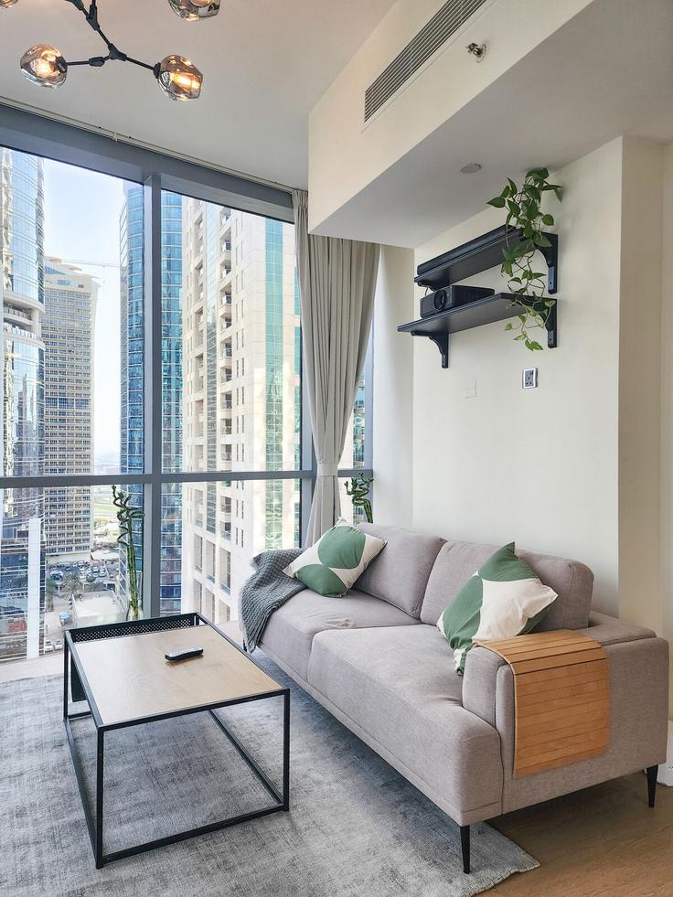 Elegante sala de estar con mobiliario moderno en un apartamento en Building Cluster D - higuests-vacation-homes-rentals - 1473604 en Al Thanyah Fifth, Dubai