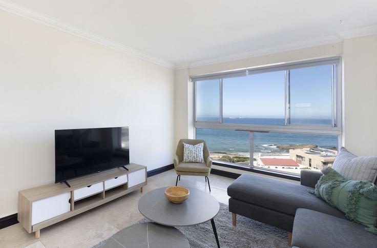 Salle de séjour élégante avec mobilier moderne dans un appartement à Building Sir David Baird Drive - host-agents - 1519649 à Bloubergstrand, Cape Town