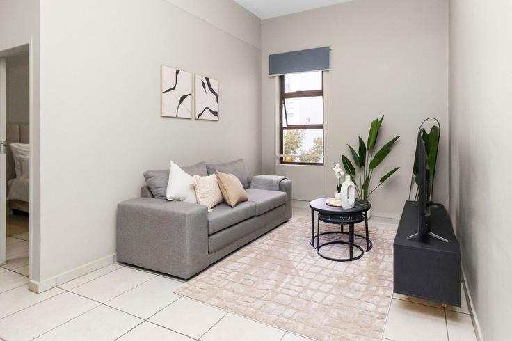 Elegante sala de estar con mobiliario moderno en un apartamento en Building Sturdee Avenue - host-agents - 1519803 en Rosebank, Johannesburg