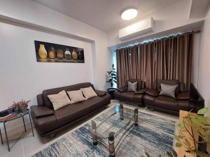 Sala de estar elegantemente projetada com móveis modernos em um apartamento no Building Rizal Drive - hosteeva - 1570752 em Makati City, Makati City