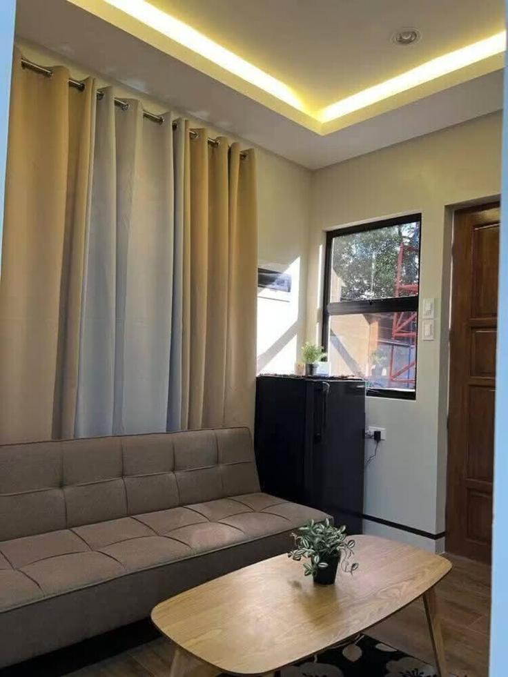 Sala de estar elegantemente projetada com móveis modernos em um apartamento no Building National Road - hosteeva - 1607030 em Hinoba-an, Hinoba-an