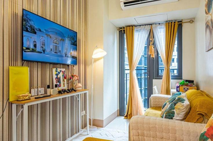 Sala de estar elegantemente projetada com móveis modernos em um apartamento no Building Mall of Asia - Cavite City - hosteeva - 1508199 em Malate, Pasay City Sala de estar elegantemente projetada com móveis modernos em um apartamento no Building Mall of Asia - Cavite City - hosteeva - 1508199 em Malate, Pasay City