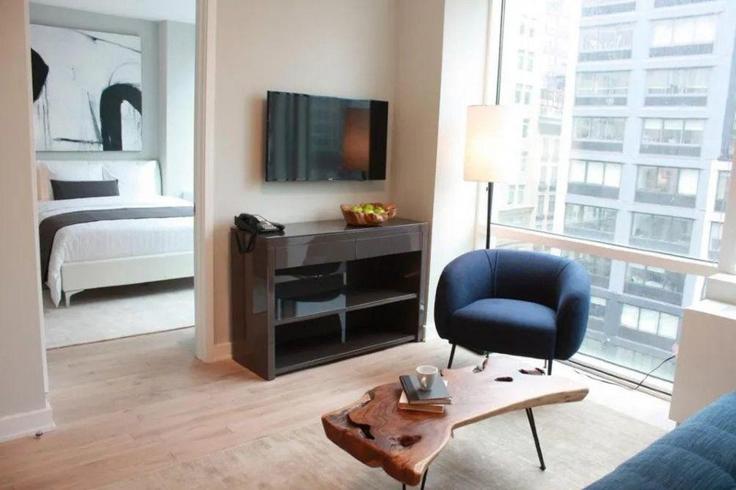 Sala de estar elegantemente projetada com móveis modernos em um apartamento no Building 7th Avenue - hosteeva - 1355939 em Manhattan, New York Sala de estar elegantemente projetada com móveis modernos em um apartamento no Building 7th Avenue - hosteeva - 1355939 em Manhattan, New York