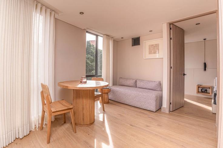 Mesa de comedor con elegantes sillas en un apartamento en Building Diagonal 75 - housy-host - 1327212 en Laureles - Estadio, Medellin, Medellín