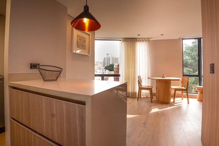 Mesa de comedor con elegantes sillas en un apartamento en Building Diagonal 75 - housy-host - 1327213 en Laureles - Estadio, Medellin, Medellín