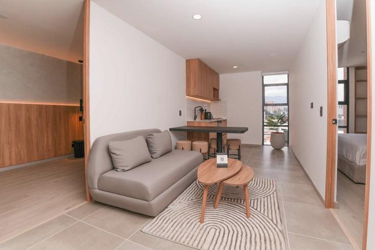 Sala de estar elegantemente projetada com móveis modernos em um apartamento no Building Carrera 43A - housy-host - 1327170 em La Candelaria, Medellín