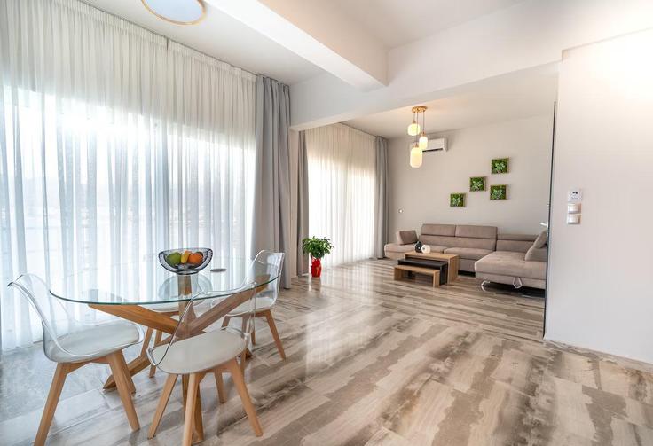 Elegante sala de estar con mobiliario moderno en un apartamento en Building Menelaou - imberal - 1459563 en Loutra Elenis, Corinthia
