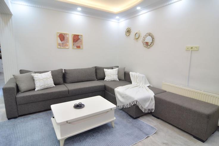 Elegante sala de estar con mobiliario moderno en un apartamento en Building Görgülü Sokak - ipmhomes - 1335845 en Beylikdüzü, İstanbul Elegante sala de estar con mobiliario moderno en un apartamento en Building Görgülü Sokak - ipmhomes - 1335845 en Beylikdüzü, İstanbul