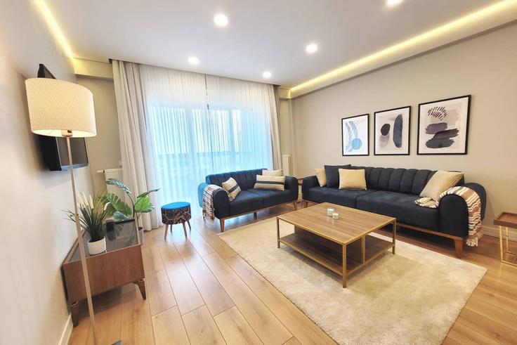 Sala de estar elegantemente projetada com móveis modernos em um apartamento no Building Halkalı Caddesi - ipmhomes - 1335778 em Küçükçekmece, İstanbul