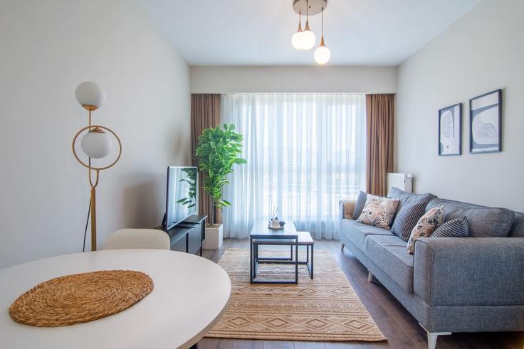 Sala de estar elegantemente projetada com móveis modernos em um apartamento no Building Başak - ipmhomes - 1335785 em Başakşehir, İstanbul