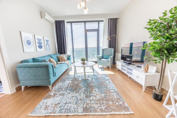 Sala de estar elegantemente projetada com móveis modernos em um apartamento no Building Bahçeşehir Esenyurt Yan Yolu - ipmhomes - 1514655 em Avcılar, İstanbul