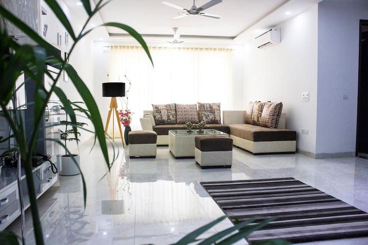 Salle de séjour élégante avec mobilier moderne dans un appartement à Building Lotus Avenue 1289 - karavan-suites-private-limited - 1621240 à Kanahi, Gurugram Salle de séjour élégante avec mobilier moderne dans un appartement à Building Lotus Avenue 1289 - karavan-suites-private-limited - 1621240 à Kanahi, Gurugram
