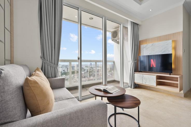 Elegante sala de estar con mobiliario moderno en un apartamento en Building Cikini - kozystay-1 - 1530219 en Menteng, Central Jakarta City Elegante sala de estar con mobiliario moderno en un apartamento en Building Cikini - kozystay-1 - 1530219 en Menteng, Central Jakarta City