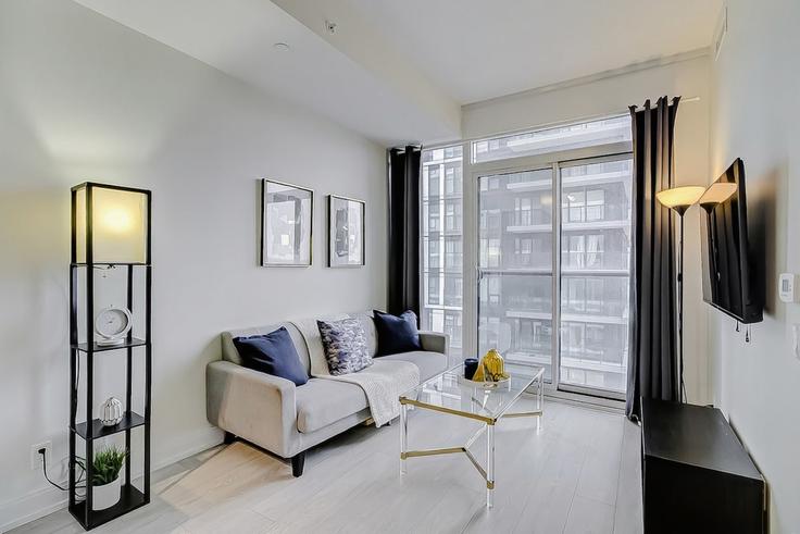 Salle de séjour élégante avec mobilier moderne dans un appartement à Building Dundas Street East - life-suites - 1582433 à Old Toronto, Toronto
