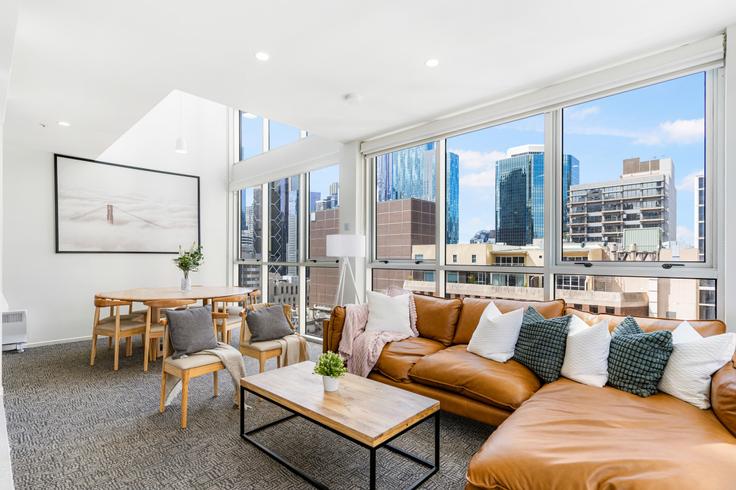 Elegante sala de estar con mobiliario moderno en un apartamento en Building William Street - live-luxe - 1645983 en Melbourne, Melbourne