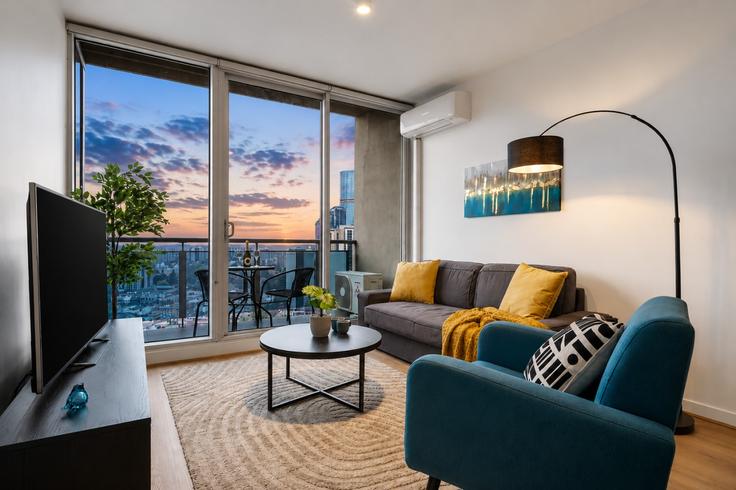 Elegante sala de estar con mobiliario moderno en un apartamento en Building Swanston Street - live-luxe - 1645935 en Melbourne, Melbourne