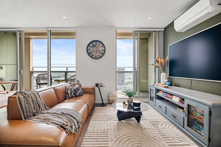 Elegante sala de estar con mobiliario moderno en un apartamento en Building Collins Street - live-luxe - 1645959 en Docklands, Melbourne