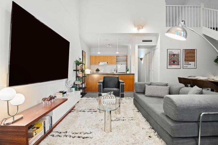 Elegante sala de estar con mobiliario moderno en un apartamento en Building Southbank Boulevard - live-luxe - 1645952 en Southbank, Melbourne