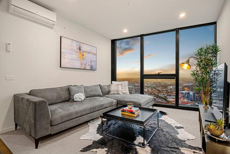 Elegante sala de estar con mobiliario moderno en un apartamento en Building A'Beckett Street - live-luxe - 1646001 en Melbourne, Melbourne Elegante sala de estar con mobiliario moderno en un apartamento en Building A'Beckett Street - live-luxe - 1646001 en Melbourne, Melbourne